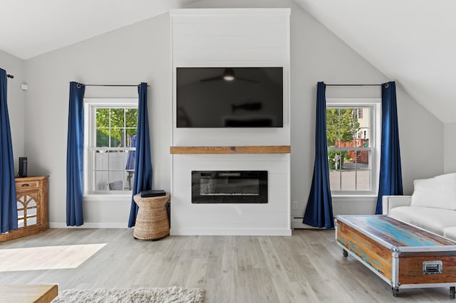 27 Seaside Ave, Saco, ME 04072 - living area with vaulted ceiling, wood finished floors, and a glass covered fireplace