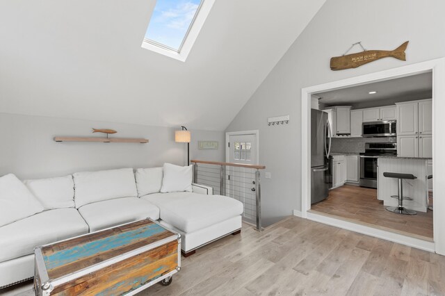 27 Seaside Ave, Saco, ME 04072 - living room featuring light wood-style flooring, a skylight, healthy amount of natural light, and high vaulted ceiling