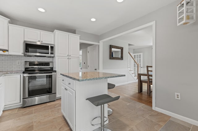 27 Seaside Ave, Saco, ME 04072 - kitchen featuring stainless steel appliances, a breakfast bar, white cabinetry, and recessed lighting