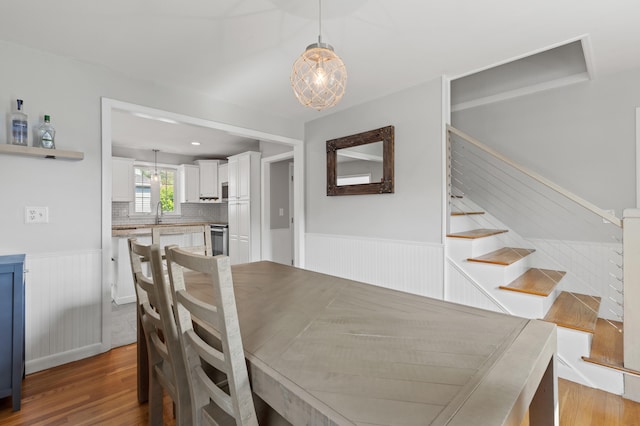 27 Seaside Ave, Saco, ME 04072 - dining space featuring wainscoting, light wood-type flooring, and stairs