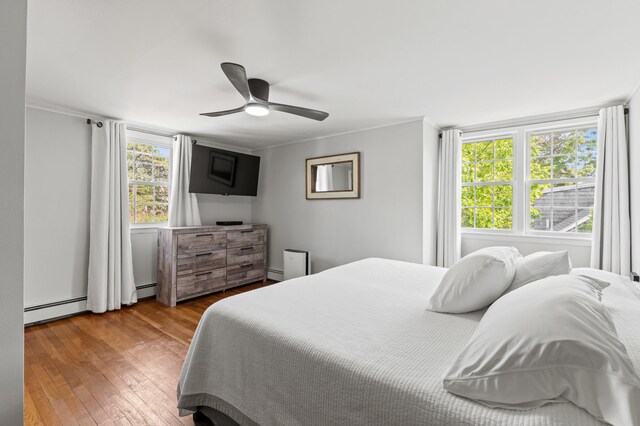 27 Seaside Ave, Saco, ME 04072 - bedroom with baseboard heating, wood-type flooring, ornamental molding, a ceiling fan, and a baseboard radiator