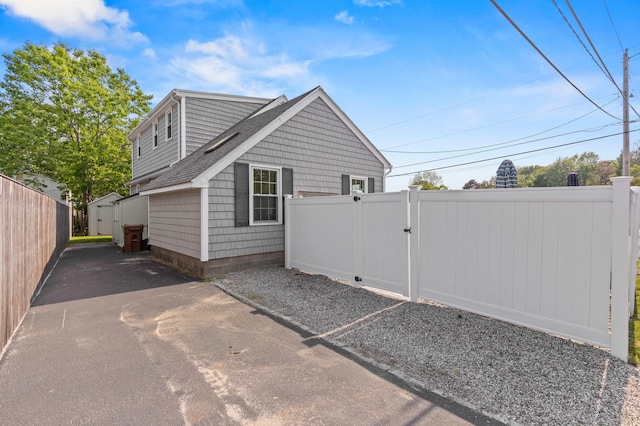 27 Seaside Ave, Saco, ME 04072 - view of side of home featuring a gate, a shed, and roof with shingles