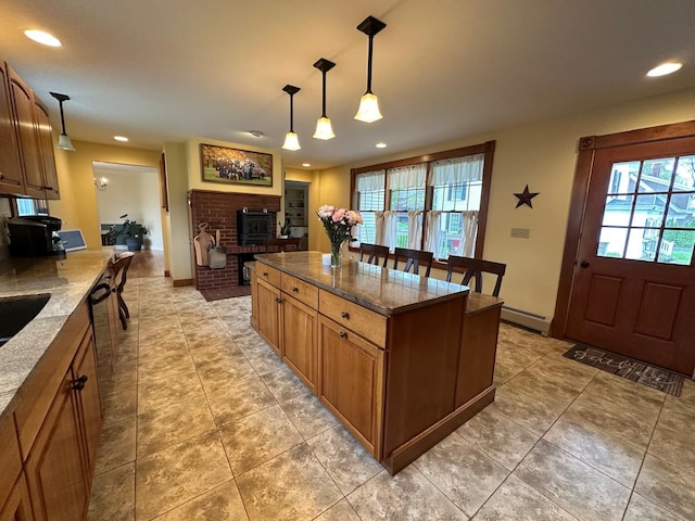46 3rd St, Presque Isle, ME 04769 - kitchen with a wood stove, a baseboard heating unit, recessed lighting, dark stone counters, and decorative light fixtures