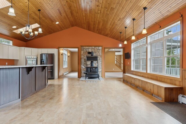 20 Motorcycle Dr, Windham, ME 04062 - kitchen with appliances with stainless steel finishes, a wood stove, vaulted ceiling, light countertops, and plenty of natural light