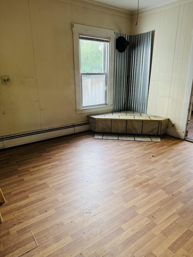 156 Railroad St, Clinton, ME 04927 - empty room featuring light wood-style flooring, a baseboard heating unit, ornamental molding, and wood walls