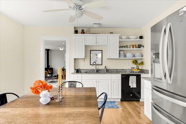 276 N Sedgwick Rd, Sedgwick, ME 04676 - kitchen featuring stainless steel fridge, a sink, a wood stove, dishwasher, and light wood-type flooring