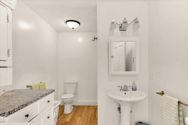 276 N Sedgwick Rd, Sedgwick, ME 04676 - bathroom featuring wood finished floors, toilet, baseboards, and a sink