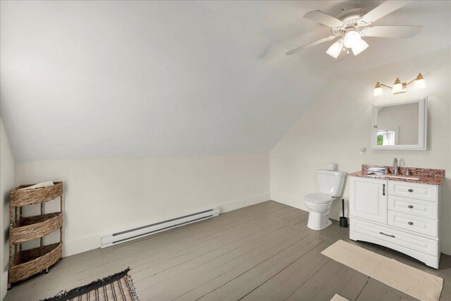 276 N Sedgwick Rd, Sedgwick, ME 04676 - bathroom with baseboard heating, vanity, lofted ceiling, toilet, and hardwood / wood-style flooring