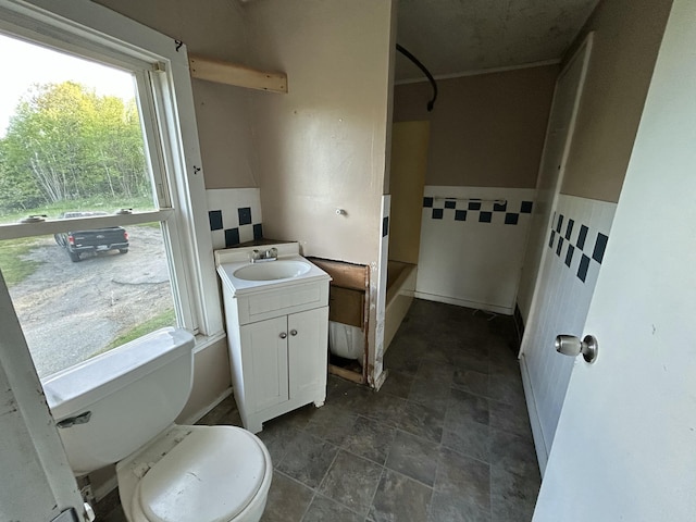 529 Main St, East Machias, ME 04630 - bathroom featuring toilet, vanity, shower / washtub combination, and stone finish flooring