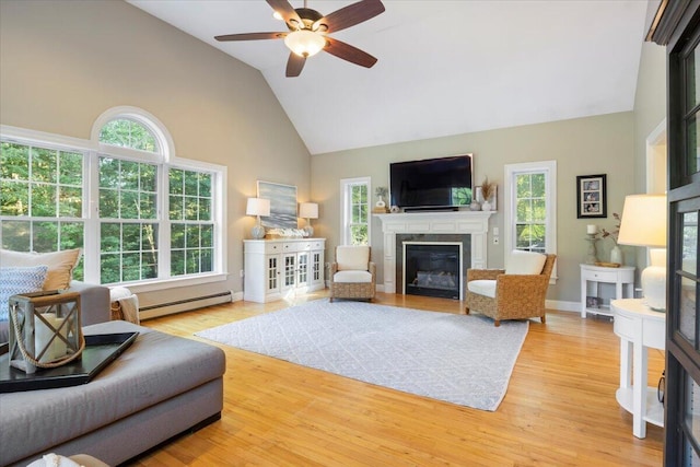 3 Highpointe Cir, Kittery, ME 03904 - living area with a baseboard radiator, high vaulted ceiling, a glass covered fireplace, plenty of natural light, and ceiling fan