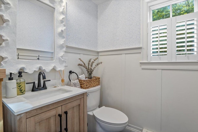 3 Highpointe Cir, Kittery, ME 03904 - bathroom featuring a decorative wall, toilet, vanity, healthy amount of natural light, and a wainscoted wall