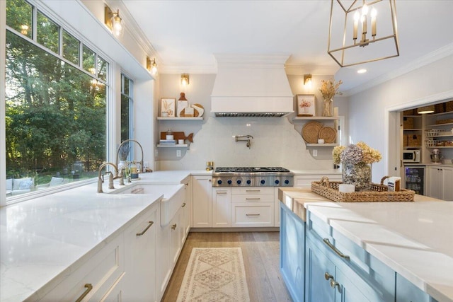 3 Highpointe Cir, Kittery, ME 03904 - kitchen featuring open shelves, beverage cooler, custom exhaust hood, light wood finished floors, and ornamental molding