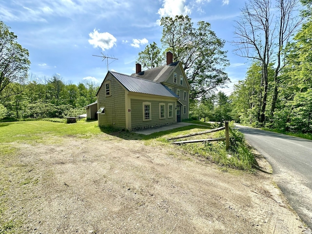 13 Mountain Rd, Newfield, ME 04095 - view of home's exterior featuring a chimney, metal roof, and dirt driveway
