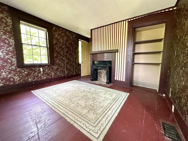 13 Mountain Rd, Newfield, ME 04095 - unfurnished living room featuring hardwood / wood-style floors, wallpapered walls, a fireplace with flush hearth, and built in features