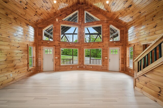 545 Back Rd, Skowhegan, ME 04976 - unfurnished living room featuring high vaulted ceiling, wood walls, wood ceiling, light wood finished floors, and stairway