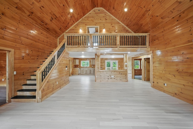 545 Back Rd, Skowhegan, ME 04976 - unfurnished living room with high vaulted ceiling, wooden walls, wood finished floors, wooden ceiling, and stairway