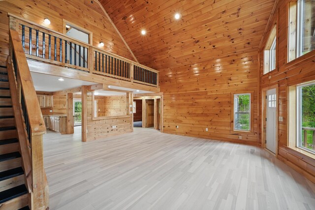 545 Back Rd, Skowhegan, ME 04976 - unfurnished living room featuring high vaulted ceiling, stairs, wood walls, wood finished floors, and recessed lighting