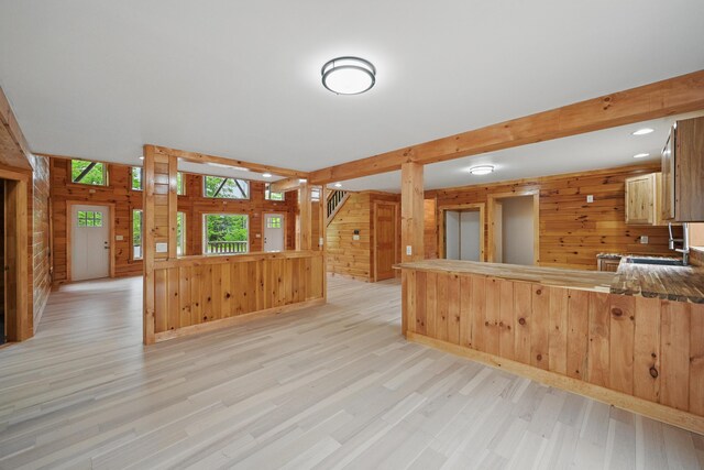 545 Back Rd, Skowhegan, ME 04976 - kitchen with wooden walls, light wood-type flooring, beamed ceiling, a peninsula, and a sink