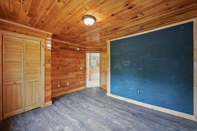 545 Back Rd, Skowhegan, ME 04976 - unfurnished bedroom featuring baseboards, wood finished floors, wood ceiling, wood walls, and a closet