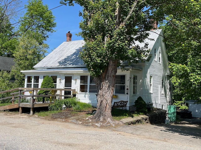 96 French St, Acton, ME 04001 - view of front of house with a chimney, metal roof, and a deck
