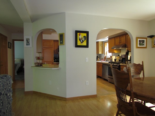 155 Crystal Cv, Waldoboro, ME 04572 - dining room featuring light wood finished floors, arched walkways, and baseboards