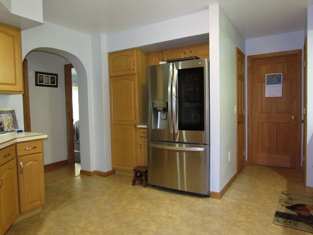 155 Crystal Cv, Waldoboro, ME 04572 - kitchen with stainless steel refrigerator with ice dispenser, arched walkways, baseboards, and light countertops