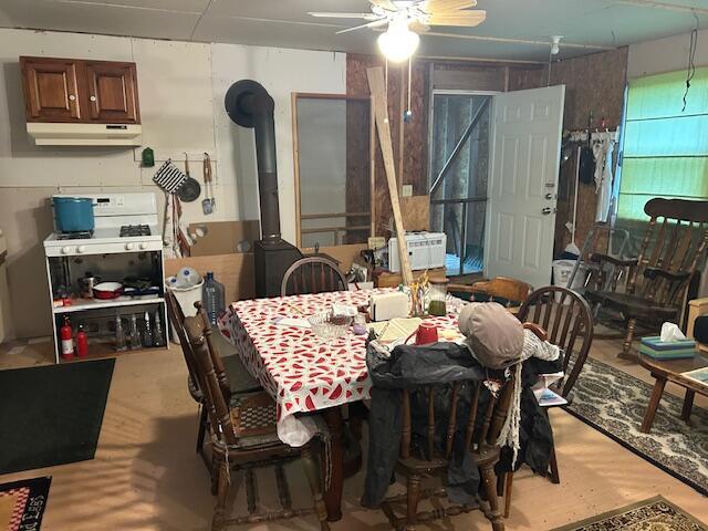12 Beach View Rd, Dover-Foxcroft, ME 04426 - dining area featuring a ceiling fan and a wood stove