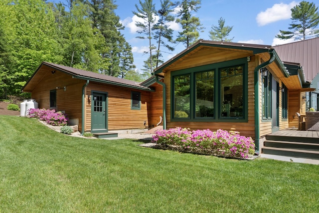 134 Zakelo Rd, Harrison, ME 04040 - rear view of house with a deck, a lawn, and metal roof