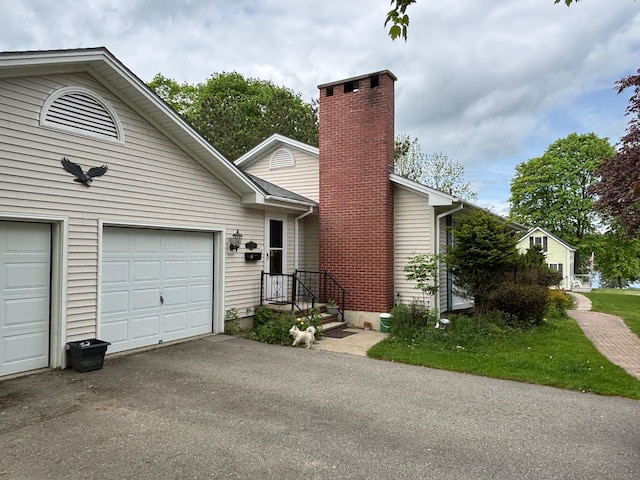 16 Steamboat St, Calais, ME 04619 - view of front facade with a chimney, asphalt driveway, and an attached garage