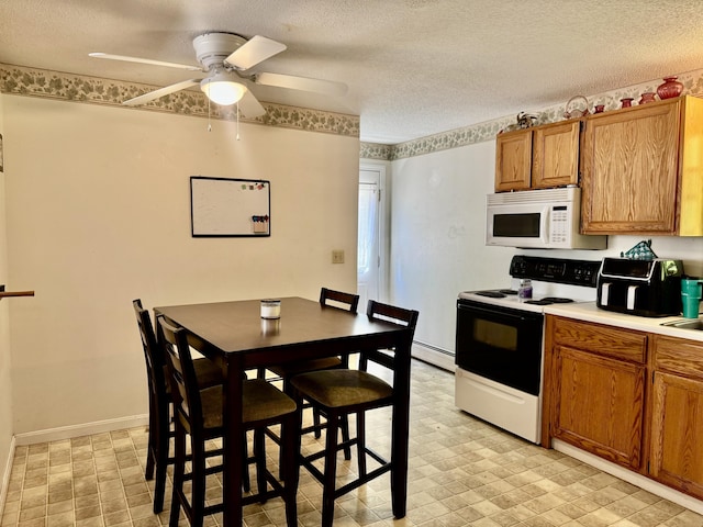 323 Main St S, Searsmont, ME 04973 - kitchen with white microwave, electric stove, baseboard heating, brown cabinetry, and ceiling fan