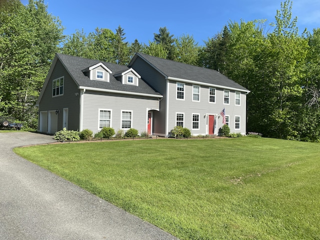 12 Cromwell Dr, Orono, ME 04473 - colonial-style house with driveway, an attached garage, a front lawn, and view of scattered trees