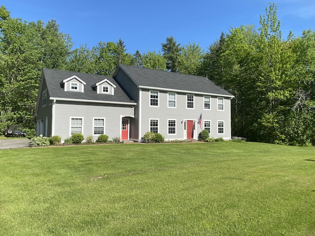 12 Cromwell Dr, Orono, ME 04473 - colonial inspired home with a front lawn, view of scattered trees, and roof with shingles