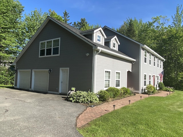 12 Cromwell Dr, Orono, ME 04473 - view of side of home featuring driveway, a lawn, and an attached garage
