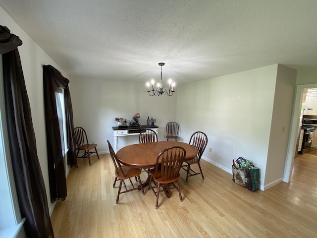 12 Cromwell Dr, Orono, ME 04473 - dining area featuring light wood-type flooring, a chandelier, and a textured ceiling