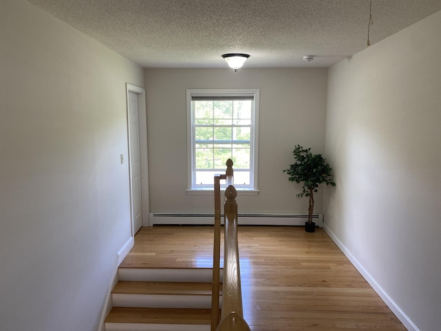 12 Cromwell Dr, Orono, ME 04473 - stairway with a baseboard heating unit, wood finished floors, and a textured ceiling