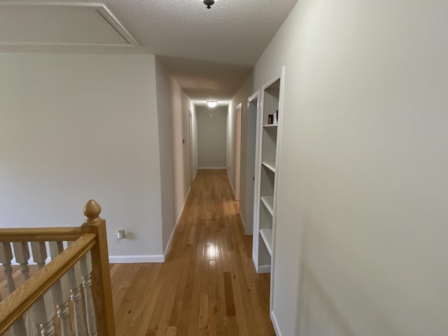 12 Cromwell Dr, Orono, ME 04473 - corridor with an upstairs landing, light wood-style floors, a textured ceiling, and attic access