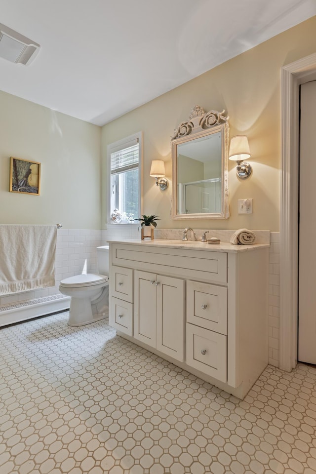 496 Coles Hill Rd, Wells, ME 04090 - bathroom featuring tile walls, wainscoting, vanity, and tile patterned floors