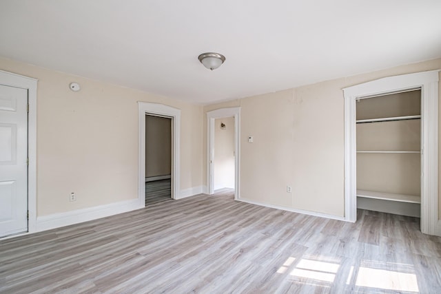 83 Brackett St, Portland, ME 04102 - unfurnished bedroom with light wood-style flooring, a spacious closet, a baseboard radiator, and a closet