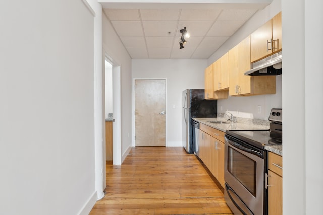 2 Main St Unit 18-416, Biddeford, ME 04005 - kitchen with appliances with stainless steel finishes, under cabinet range hood, light wood finished floors, a drop ceiling, and light brown cabinetry