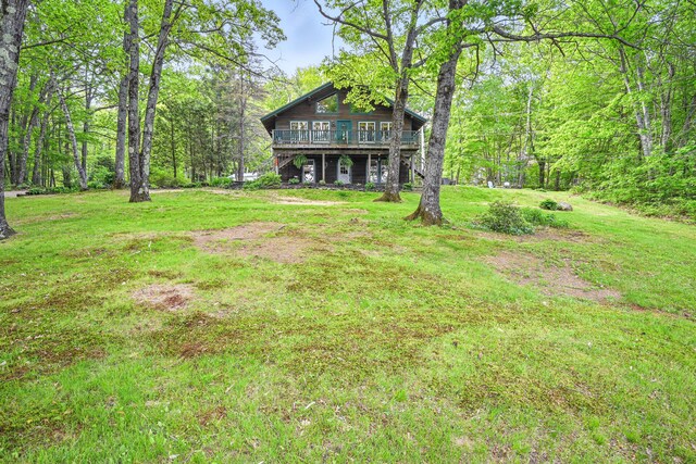 14 Greenleaf Ln, Monmouth, ME 04259 - view of grassy yard with a wooden deck and a view of trees