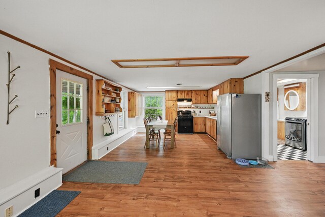 14 Greenleaf Ln, Monmouth, ME 04259 - kitchen with black range with gas cooktop, freestanding refrigerator, brown cabinets, light wood-style flooring, and range