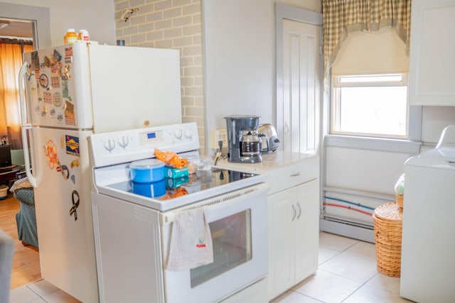 50 Green St, Biddeford, ME 04005 - kitchen with electric range, washer / clothes dryer, baseboard heating, light tile patterned floors, and white cabinets