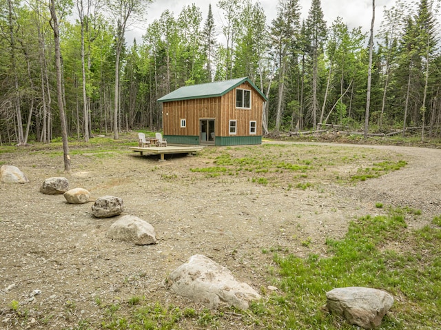 105 Gales Rd, Abbot, ME 04406 - view of yard featuring a deck, a view of trees, and an outbuilding