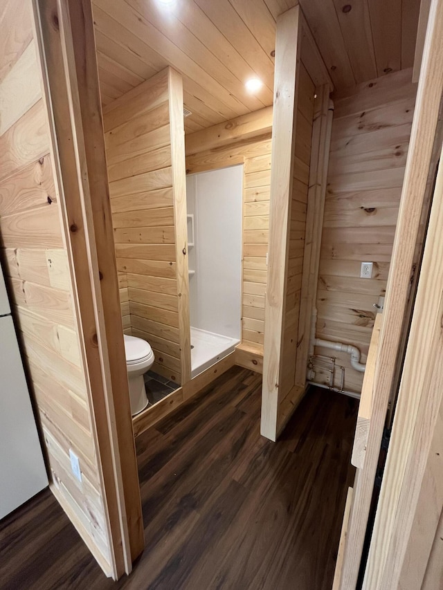 105 Gales Rd, Abbot, ME 04406 - full bath featuring toilet, wood finished floors, wood walls, wooden ceiling, and a stall shower