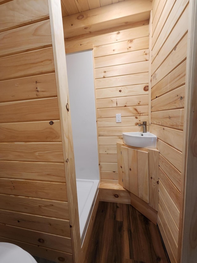 105 Gales Rd, Abbot, ME 04406 - bathroom featuring wood finished floors, vanity, wooden walls, and toilet