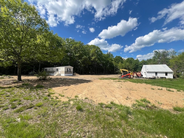 440 High St, Sanford, ME 04073 - view of yard featuring dirt driveway, an outbuilding, and a forest view