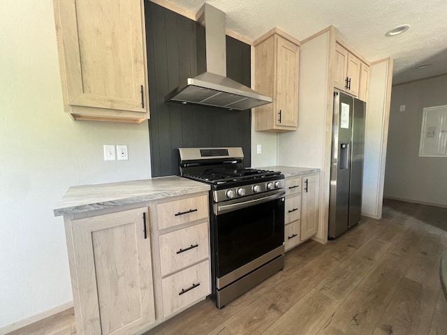 440 High St, Sanford, ME 04073 - kitchen featuring stainless steel appliances, wall chimney range hood, light brown cabinetry, wood finished floors, and light countertops