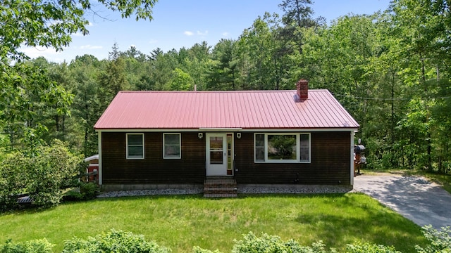 23 E Eleanor Ave, Standish, ME 04084 - view of front of property with entry steps, a chimney, a front lawn, and a wooded view