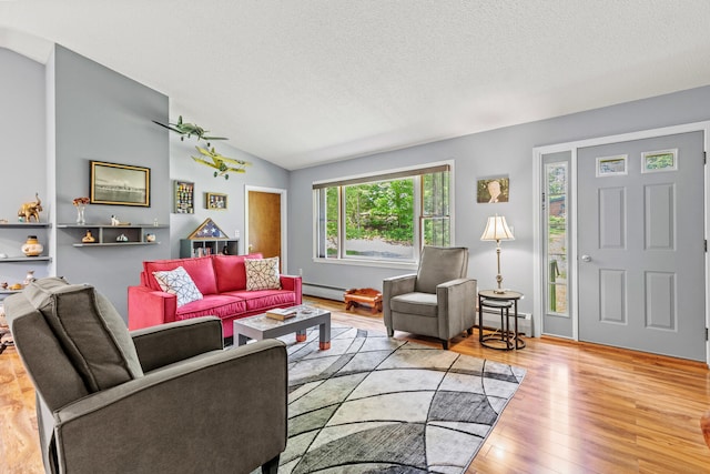 23 E Eleanor Ave, Standish, ME 04084 - living area featuring a baseboard heating unit, vaulted ceiling, a textured ceiling, a baseboard radiator, and wood finished floors