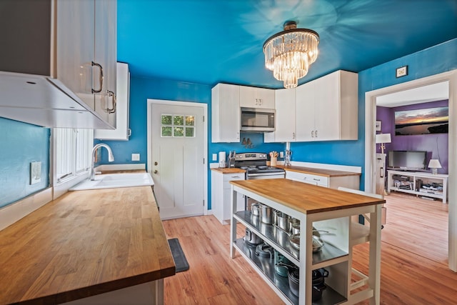 194 Larkin St, Bangor, ME 04401 - kitchen with appliances with stainless steel finishes, a sink, wood counters, light wood finished floors, and white cabinetry